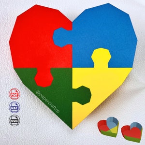 Puede incluir: Un rompecabezas de papel en forma de corazón con cuatro piezas en rojo, azul, verde y amarillo. El rompecabezas está ensamblado en forma de corazón. La imagen también muestra dos versiones más pequeñas del rompecabezas, una ensamblada y otra desensamblada.