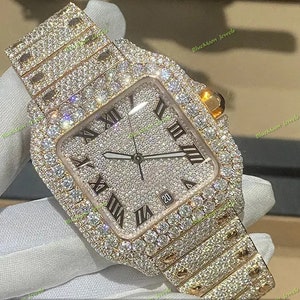 May include: A gold-tone watch with a square face and a diamond-encrusted band. The watch face has Roman numeral hour markers and a date window at the 4 o'clock position.