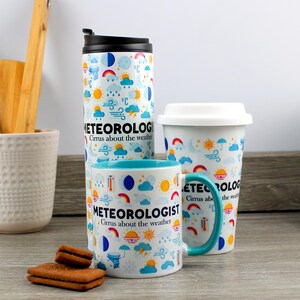 May include: Three mugs with a white background and blue accents. The mugs feature a variety of weather icons and the text "Meteorologist Cirrus about the weather".