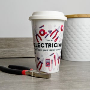 May include: White ceramic travel mug with a red, black, and gray design of electrical tools and the text "I'm an Electrician. What's your super power?"