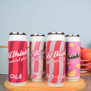 Op de afbeelding: Vier geïsoleerde roestvrijstalen bekers met een retro blikjesontwerp. De bekers zijn rood, roze en wit met zwarte tekst. De tekst op de bekers luidt "Old Drinks with natural juices" en "Cola", "Cream Soda", "Diet-Cola" en "Drinks with natural juices".