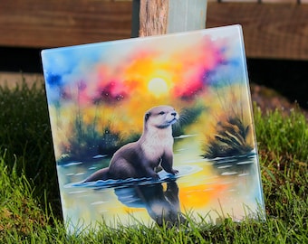 Może przedstawiać: Szklany podkładka pod kubek z kolorową sceną zachodu słońca przedstawiającą brązową wydrę pływającą w zbiorniku wodnym. Wydra patrzy w prawo, a zachód słońca jest w tle.