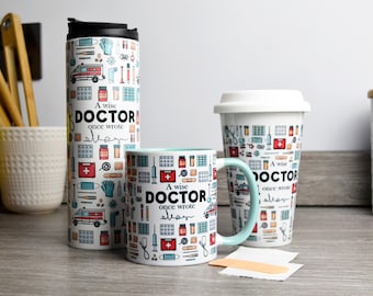 May include: Three mugs with a medical theme. The mugs are white with blue and red accents. The mugs feature a repeating pattern of medical supplies, including bandages, pills, syringes, and a stethoscope. The text on the mugs reads "A wise doctor once wrote..."