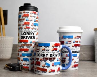 May include: A white travel tumbler with a black lid, a white ceramic mug with a blue handle, and a white travel mug with a white lid. All items feature a repeating pattern of colorful trucks and the text I'm a trucking good LORRY DRIVER.