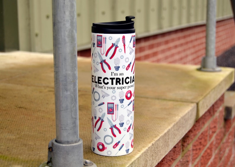 May include: White travel mug with a black lid and a pattern of electrical tools and the text "I'm an Electrician. What's your super power?"