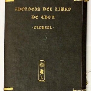 Op de afbeelding: Een zwart rechthoekig boek met gouden letters die APOLOGIA DEL LIBRO DE THOT -ELEUZEL- spellen. De kaft bevat een gouden embleem van een zon, een scarabee en de letter B, met gouden draadbinding zichtbaar aan de linker- en rechterrand.