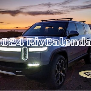 May include: A silver SUV with a black roof rack and the text "2024 RivCalendar" on the front. The car is parked in a desert setting with a sunset in the background.