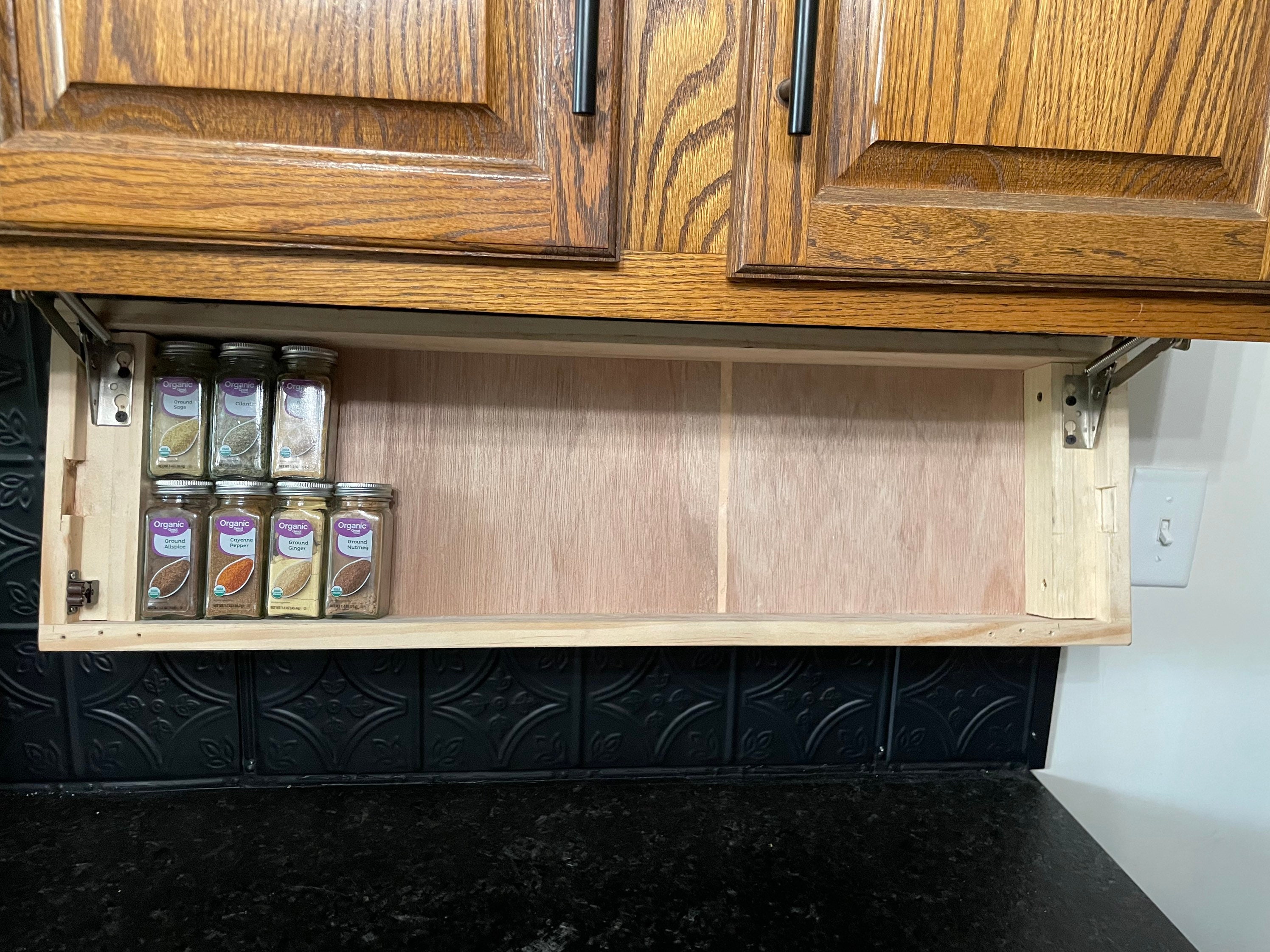 Hidden hinged spice rack