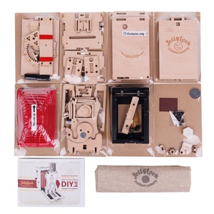 May include: A wooden DIY instant camera kit with instructions, a cloth bag, and all the parts needed to build the camera. The camera is made of wood and has a red film holder. The kit includes a small bag of screws and a small piece of brown felt.