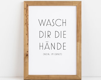 May include: A framed print with the text "Wasch dir die Hände (Nein, im Ernst)" in black lettering on a white background.
