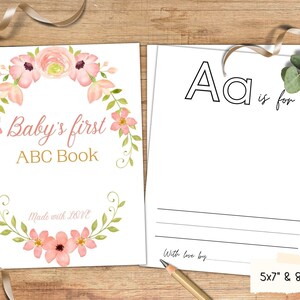 May include: A printable baby's first ABC book with a pink floral design. The cover features a wreath of pink flowers and green leaves with the text "Baby's first ABC Book" and "Made with LOVE". The inside page shows the letter "A" with the text "Aa is for" and a blank space to write in the word that starts with the letter "A".
