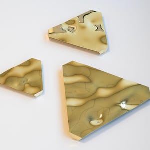 Może przedstawiać: Trzy abstrakcyjne, geometryczne dzieła sztuki na ścianę. Każdy element ma jasnobrązowy i beżowy wzór marmuru. Elementy są ułożone na białym tle, tworząc nowoczesną, minimalistyczną estetykę. Elementy są różnej wielkości.