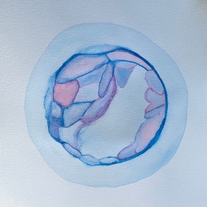 Könnte beinhalten: Aquarellkunstwerk mit einem kreisförmigen Design in Blau- und Rosatönen, das einer Zelle oder einer abstrakten Form ähnelt. Die Namen "LENNOX" und "Peyton" sind in schwarzer Schrift unter dem Kunstwerk geschrieben.