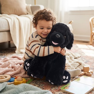 May include: A large, plush black dog stuffed animal with soft fur, floppy ears, a black nose, and a pink tongue. The toy features white paw pad accents on its feet and is designed with a friendly, smiling expression and a soft, huggable body.