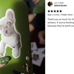 A person's hand holding a green water bottle with a sticker of a dog on it. The person is also wearing green nail polish.