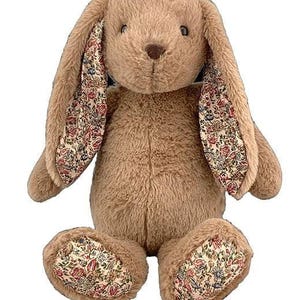 A brown stuffed bunny toy with floral patterns on its ears and feet.
