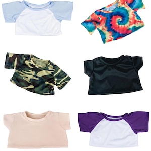 a variety of colorful t-shirts, including a blue and white top, a tie-dye top, a camouflage top, a black top, a white top, and a purple top.