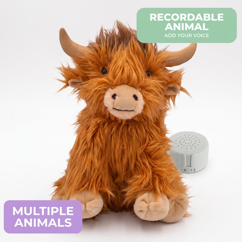 a stuffed animal toy, specifically a large brown furry animal resembling a yak or a similar creature. The toy is sitting on a white background, and there is a small speaker or sound maker next to it.