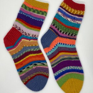 May include: A pair of colorful striped socks with a yellow, red, and blue color scheme. The socks are knitted with a variety of different colored yarns.