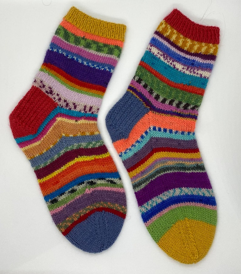 May include: A pair of colorful striped socks with a yellow, red, and blue color scheme. The socks are knitted with a variety of different colored yarns.