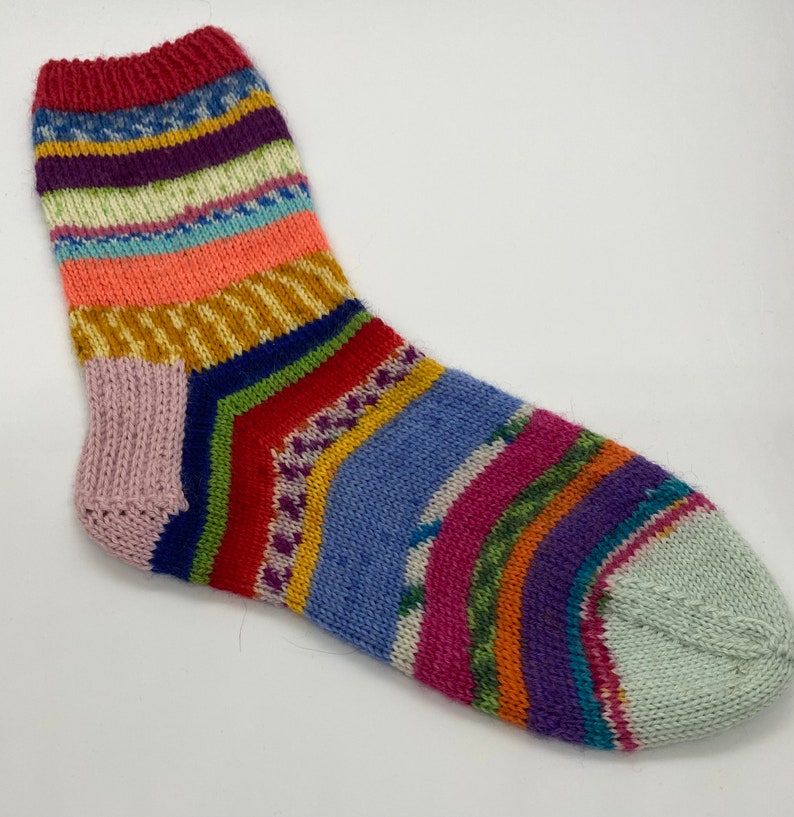 May include: A colorful striped knitted sock with a light blue heel and toe.
