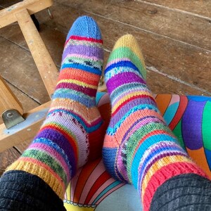 May include: A pair of colorful striped socks with a rainbow pattern. The socks are made of a soft, knitted fabric and are perfect for keeping your feet warm and cozy.