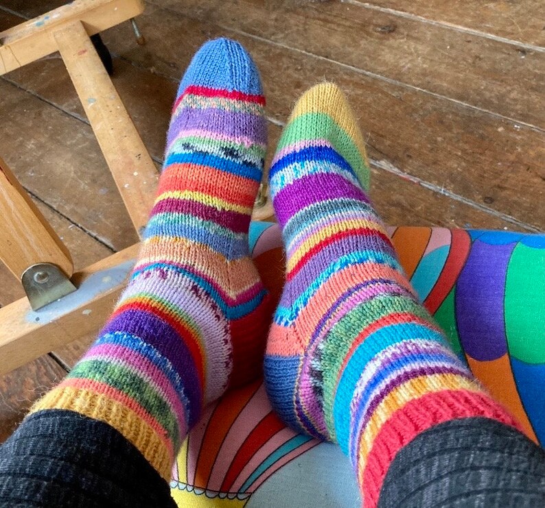 May include: A pair of colorful striped socks with a rainbow pattern. The socks are made of a soft, knitted fabric and are perfect for keeping your feet warm and cozy.