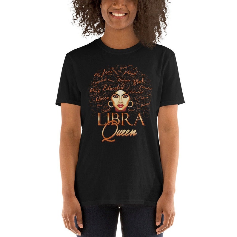 May include: Black t-shirt featuring a brown and gold graphic of a woman's face with the words "LIBRA Queen" underneath. The graphic is surrounded by words such as "Black", "Queen", "Educated", "Smart", "Talented", and "Beautiful".