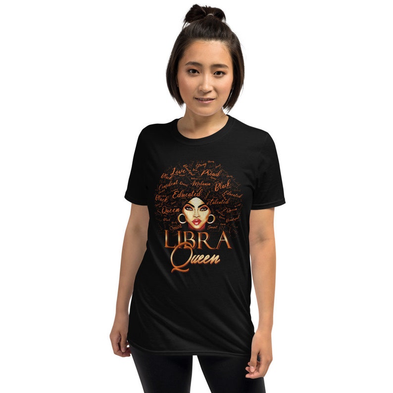 May include: Black t-shirt featuring a brown and gold graphic of a woman's face with the words "LIBRA QUEEN" underneath. The graphic includes words such as "Love", "Queen", "Educated", "Talented", and "Strong" surrounding the woman's face.