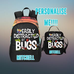 May include: Black backpack and matching lunch bag set. The backpack features a colorful sunset design at the top and the text "EASILY DISTRACTED BY BUGS" with bug illustrations. The lunch bag has the same design and text. Both items are personalized with the name "MITCHELL".