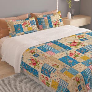 May include: A bed featuring a patchwork quilt and two matching pillowcases with a pattern of blue, pink, and yellow squares. The design includes floral prints, gingham checks, and solid colors, with prominent red rose clusters on a cream background.