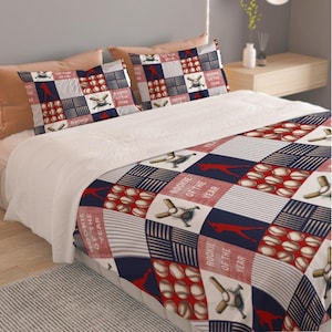 May include: Baseball-themed bedding set featuring a quilt and two pillowcases. The design includes baseballs, bats, and a baseball player silhouette in red, white, and navy blue. The text "Rookie of the Year" is also visible.