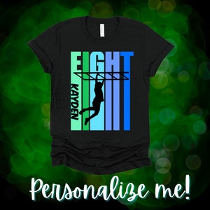May include: Black t-shirt with a blue and green design featuring a silhouette of a person on a climbing frame. The text "EIGHT" and "KAYDEN" are printed on the shirt.