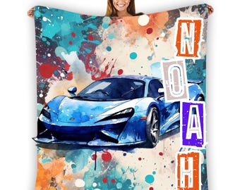 Puede incluir: Una pintura de acuarela azul de un coche deportivo con salpicaduras de pintura coloridas en el fondo. El nombre "NOAH" está escrito en letras grandes en el lado derecho de la imagen.