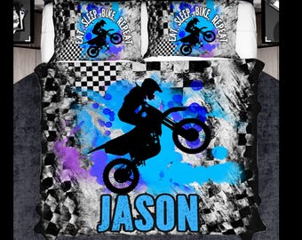 May include: A bedding set featuring a quilt and two pillowcases with a black and white checkered pattern, blue and purple paint splatters, and a silhouette of a person on a dirt bike. The text reads EAT, SLEEP, BIKE, REPEAT and JASON.