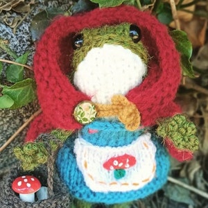 Lalka żaba robiona na drutach – Czerwony Kapturek – Ręcznie robiona żaba amigurumi z czerwonym płaszczem, sukienką, fartuchem, filcowymi butami i koszykiem z grzybami