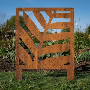 May include: A rectangular metal garden screen featuring a laser-cut fern leaf pattern. The panel has a weathered, rusted brown finish with a textured surface. It is supported by two short, integrated legs at the base, designed for ground placement.