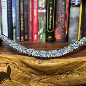 May include: A black leather horse browband with a silver glitter design. The browband is on a wooden surface with a logo that says "If The Bonnet Fits".