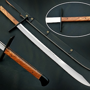 Puede incluir: Una espada larga de plata con mango de madera y vaina de cuero negro. La espada tiene una hoja recta y una guarda. La vaina tiene un patrón de costura decorativo.