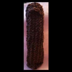 Puede incluir: Un calentador de taza o botella de agua de punto de ganchillo marrón.