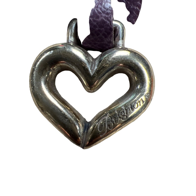 May include: A silver heart-shaped charm with the word "Brighton" engraved on it.