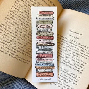 Peut inclure: Un marque-page en papier vertical présentant une illustration à l'aquarelle d'une pile de dix-sept livres classiques avec des titres comme The Secret Garden, Little Women et The Voyage of the Dawn Treader, signé par l'artiste Katie Anne Potter.
