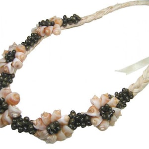 May include: A white braided rope necklace with clusters of small pink and brown seashells and black beads.