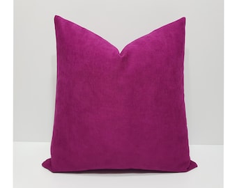 May include: A square throw pillow cover in a vibrant magenta color. The fabric has a soft, matte, suede-like texture with a visible nap. The pillow is plumped to create a slight indentation at the top center, showcasing its plush, filled form.