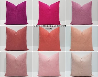 May include: A grid of nine square throw pillows in various shades of pink, magenta, coral, and peach. Each pillow features a subtle, tone-on-tone swirling pattern. The text in the center states 70 different sizes & 51 different colors.