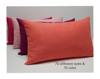 May include: Four rectangular throw pillows arranged in a row, featuring a smooth, solid-colored fabric in shades of coral, deep purple, light pink, and dark pink. The text 70 different sizes & 70 color is printed in black on the lower right side.