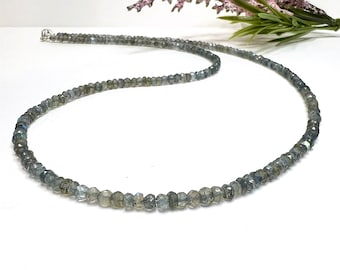 May include: A silver necklace with a strand of gray faceted labradorite beads.