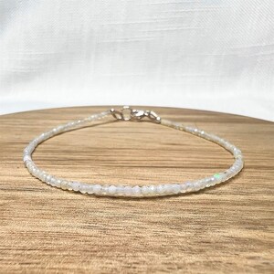 May include: A delicate white opal beaded bracelet with a silver clasp.