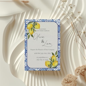 Könnte beinhalten: Hochzeitseinladung mit einem Zitronen- und Blattmotiv. Die Einladung hat einen blau-weißen Kachelrand und enthält die Namen "Olivia & Liam" sowie Veranstaltungsdetails. Der Text lautet "Request the Pleasure of Your Company".