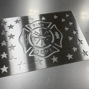 May include: A stainless steel American flag with a fire department emblem cut out in the center. The emblem features the words "FIRE DEPT." and a firefighter's axe and hose.